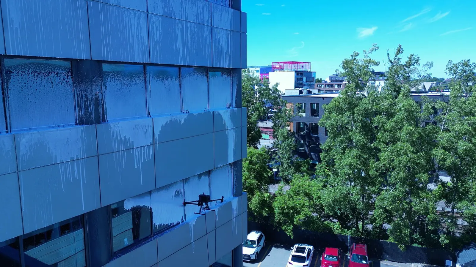 Yüksek cam cephede çalışan profesyonel temizlik dronu